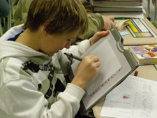 Student working with a writing tablet for the computer.